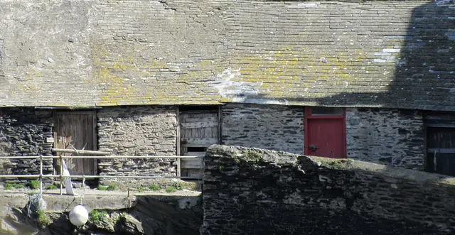 A weathered, lichen-covered slate roof over an old stone building.